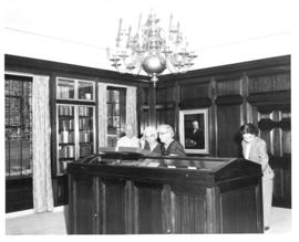 Photograph of people looking at a display case in the Kipling room at the Macdonald library