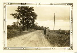 Photograph of two women standing on the side of the road along Hospital Wood, looking north towar...