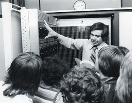 Photograph of a man giving a tour of the Dalhousie Computer Centre to a group of children