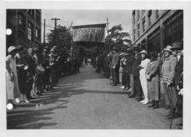 Photograph of alumni lined up on either side of a street