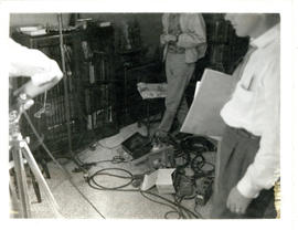 Photograph of T.V. crewmen, and equipment and cables on the floor of Thomas Head Raddall's den