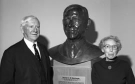 Photograph of Norman A. M. MacKenzie with a bust of himself and an unidentified woman