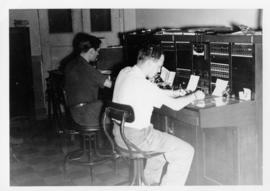 Photograph of James L. Cameron and J. Harold Warren at test board