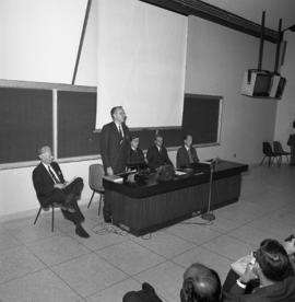 Photograph of an unidentified person speaking at the front of a classroom