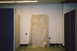 Photograph of a draped furniture unit waiting for installation during the 2001 renovation of the ...