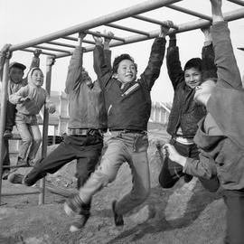 Photograph of six children playing on monkey bars in Fort Chimo, Quebec