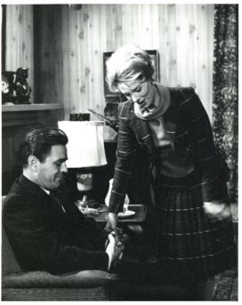 Photograph of "Neil" (James Doohan) and "Louise" (Irena Mayeska) talking in a den