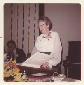 Photograph of Electa MacLennan looking at a book