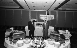 Photograph of two unidentified people with a buffet