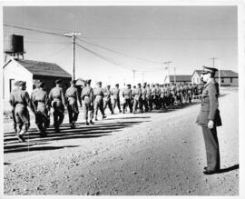 Photograph of Brigadier Roome saluting soldiers marching on a church parade, Tracadie, 1943