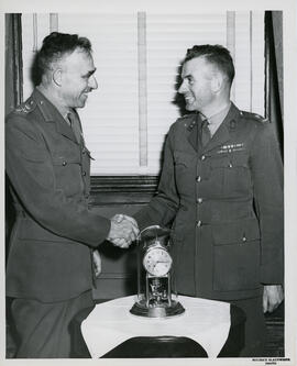 Photograph of Brigade Major Faulkner presenting a clock to Brigadier Richard Roome