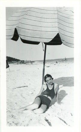 Photograph of Edith Raddall under an umbrella at Elbow Beach, Bermuda