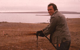 Photograph of Bill Gizyn oiling a site near Cape Parry, Northwest Territories