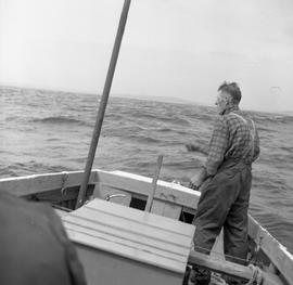 Photograph of an unidentified man standing on a boat