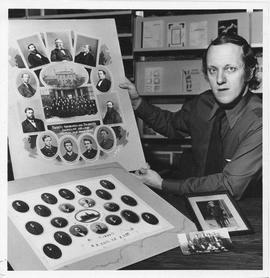 Photograph of Charles Armour holding a composite photograph of Dalhousie College faculty and stud...