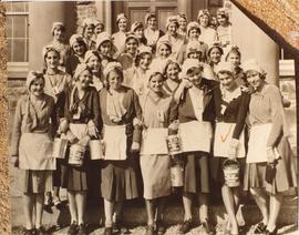Photograph of students in front of Shirreff Hall with paint cans and aprons