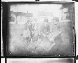 Photographic negative of children and young women on a lawn