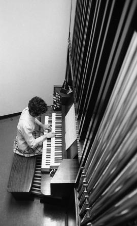 Photograph of an unidentified person playing a pipe organ