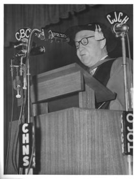 Photograph of an unidentified man speaking at the opening ceremony of the Sir James Dunn Building