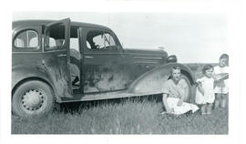 Photograph of Edith Raddall with her children beside her husband's car, taken at Summerville
