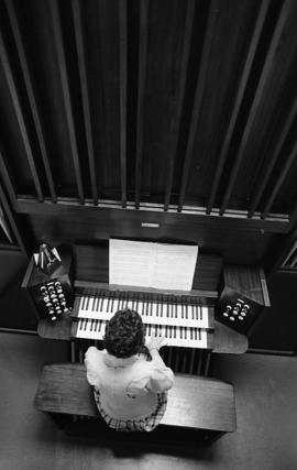 Photograph of an unidentified person playing a pipe organ