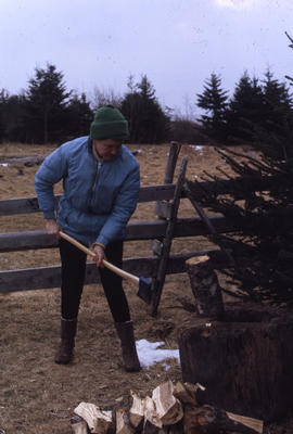 Photograph of Barbara Hinds chopping wood
