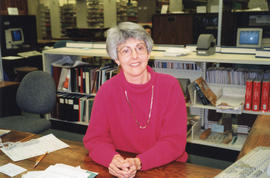 Photograph of librarian Sharon Longard behind the reference desk at the Killam Memorial Library