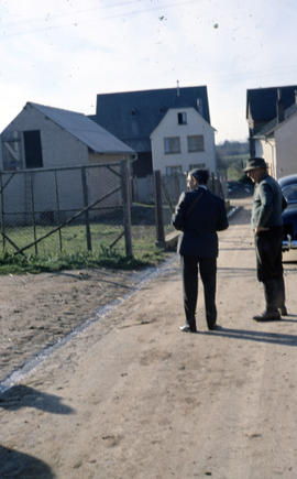 Photograph of two unidentified people standing outside in Lasserg