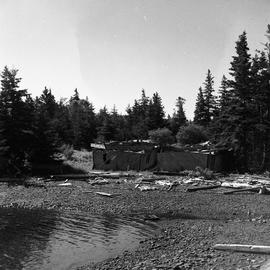 Photograph of a wrecked boat or building on a shoreline