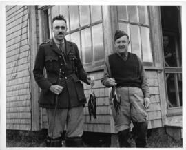 Photograph of Brigadier Roome and Major Keen holding their catches after a fishing expedition nea...