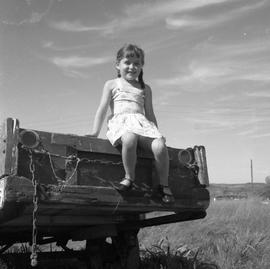 Photograph of an unidentified girl sitting on a truck