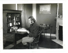 Photograph of "Colonel Larrabee" (David Murray) writing at a desk in the Simeon Perkins house in ...