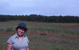 Photograph of Lynne Brennan standing in a field near the Burwash site, near Sudbury, Ontario