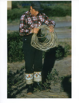 Photograph of George Koneak holding a leather rope