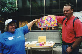 Photograph of Audrey LaPierre with an unidentified man assisting with a prize drawing at the Kill...