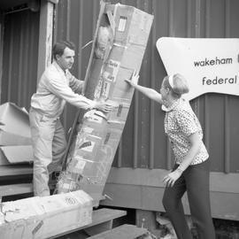 Photograph of Doreen and Collingwood Wynne moving a box in Wakeham Bay, Quebec