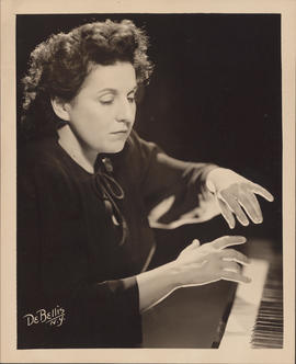 Publicity photograph of Ellen Ballon playing a piano