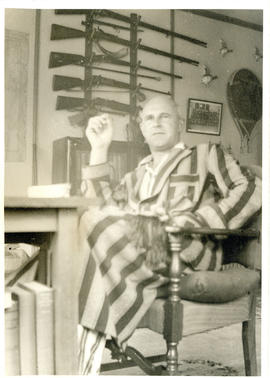 Photograph of Thomas Head Raddall sitting in his study in the morning