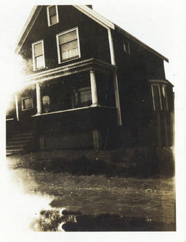 Photograph of a house with a front veranda and a bay window on the side