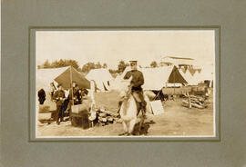 Photograph of a military person riding a white horse through camp