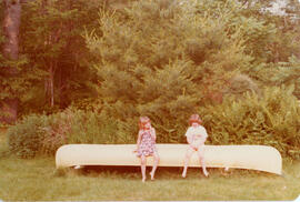 Photograph of two unidentifed children sitting on an upturned canoe at the First Roscoe Fillmore ...