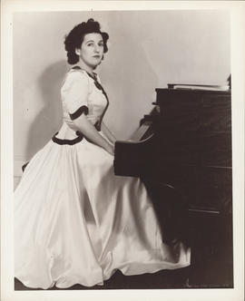Publicity photograph of Ellen Ballon sitting at a piano