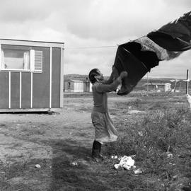 Photograph of a woman hanging laundry on a clothesline in Fort Chimo, Quebec