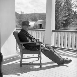 Photograph of John Drabson sitting on the verandah of the Old Men's Home in Dawson City, Yukon