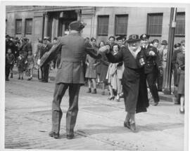 Photograph of a serviceman and an older women with military decorations on her lapel dancing on B...
