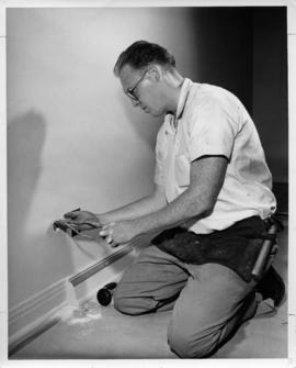Photograph of an unidentified person installing a phone jack