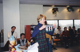 Photograph of Barbara Nielsen opening presents in Killam Memorial Library staff lounge