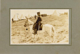 Photograph of a military person riding a white horse