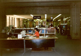 Photograph of an unidentified person working at the Killam Library reference desk