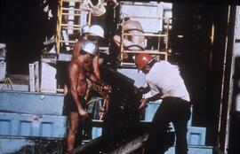 Slide depicting men operating mining equipment